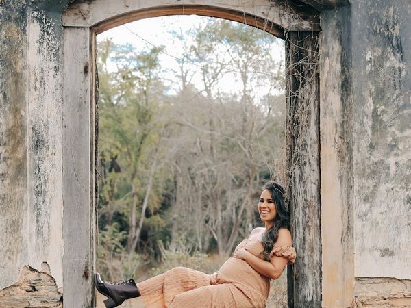 Pregnant woman meditating peacefully outdoors.